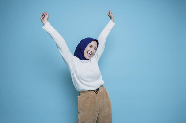 A young Asian Muslim woman with a happy successful expression wearing white shirt and hijab isolated by white background - Φωτογραφία, εικόνα