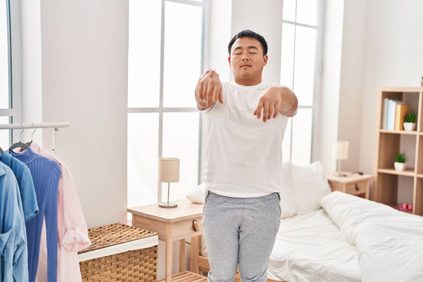 Young chinese man somnambulist sleepwalking at bedroom - Photo, Image