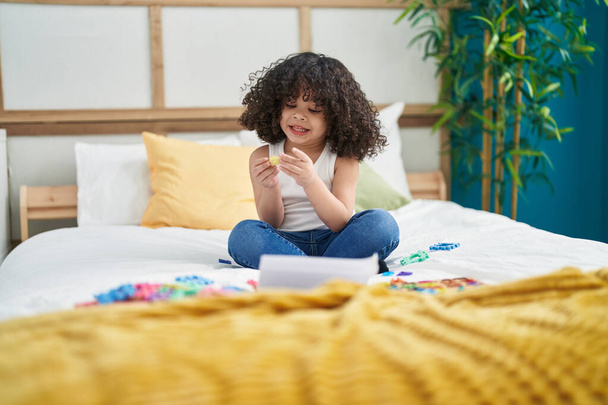 African american toddler playing with toys sitting on bed at bedroom - Φωτογραφία, εικόνα