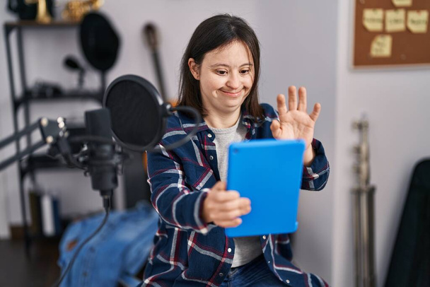 Jeune femme atteinte du syndrome du duvet musicien souriant confiant ayant un appel vidéo au studio de musique - Photo, image