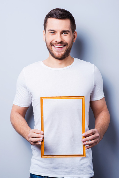 Man in T-shirt holding a picture frame - Foto, Imagem