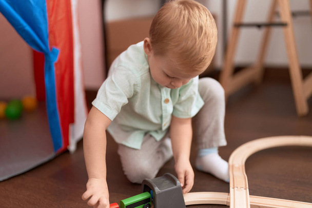 Adorable toddler playing with cars toy sitting on floor at kindergarten - Foto, immagini