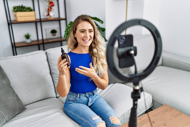 Young woman recording skin care tutorial by smartphone at home - Photo, image