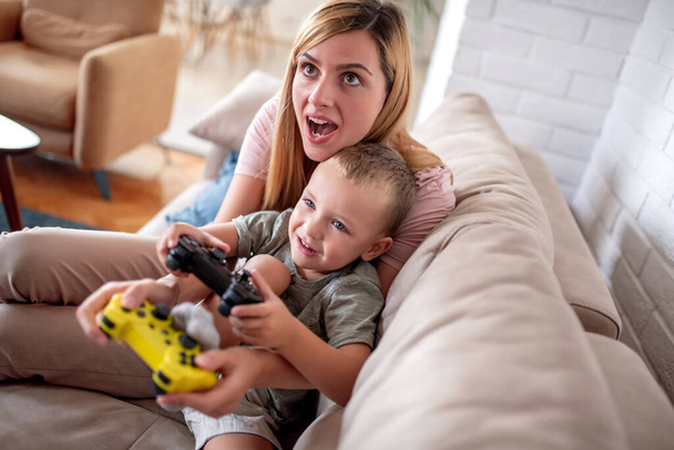 Boldog család játszik videojátékok otthon, és jól érzik magukat együtt. - Fotó, kép