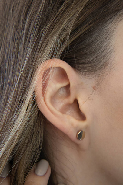 女性は密接に耳を傾ける。耳たぶのない耳、耳たぶタイプ。付属の耳たぶ - 写真・画像