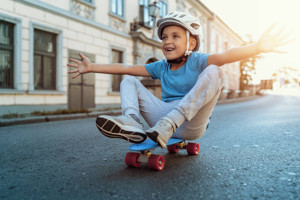 Young kid riding in the city on a skateboard. City life. - Photo, Image