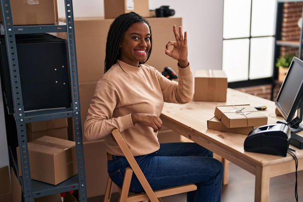 小さなビジネスで働いている若いアフリカ系アメリカ人は、指でOKサインをし、優れたシンボルをジェスチャーで笑顔  - 写真・画像