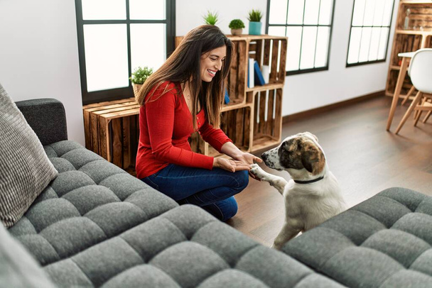 Young woman smiling confident teaching dog at home - Foto, Bild