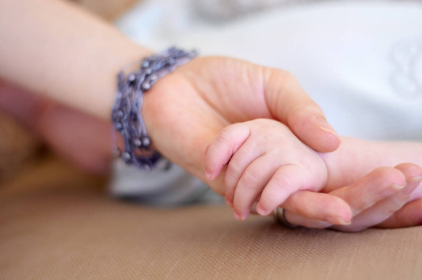 Manos pequeñas. Primer plano de una mano de bebé en la mano de su madre - Foto, imagen