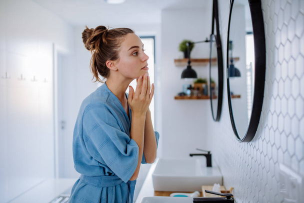 Young woman taking care of her face skin, morning beauty routine concept. - Foto, afbeelding