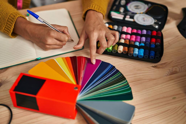 Young blonde woman dressmaker choosing cloth color at designer studio - Foto, immagini