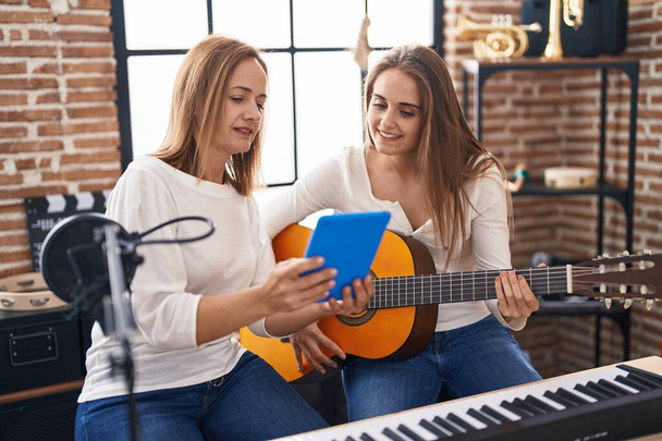 Dos mujeres músicos que tienen clases de guitarra clásica en el estudio de música - Foto, Imagen