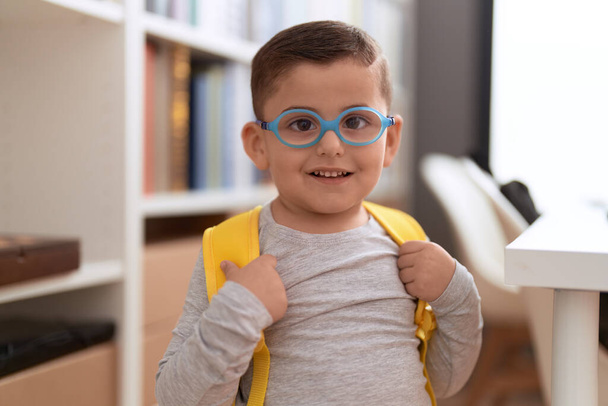 Чарівний іспаномовний учень малюка посміхається впевнено стоїть в бібліотечній школі
 - Фото, зображення