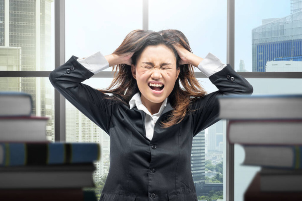 Asian businesswoman with a frustrated expression in the workplace - Photo, Image