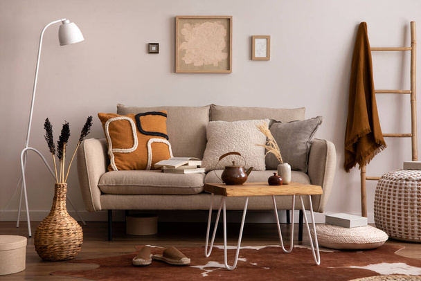 The stylish composition of living room interior with beige sofa with brown carpet, pillow, plaid, coffee table and personal accessories. beige wall with mock up poster. Home decor. Template. - Photo, image