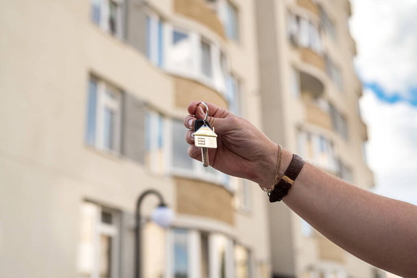  Владелец держит ключ от нового дома у риэлтора. Концепция продажи и аренды дома. - Фото, изображение