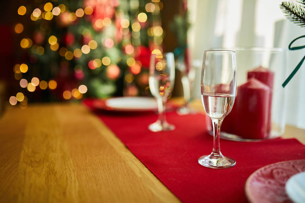 Όμορφο σκηνικό τραπεζιού με χριστουγεννιάτικες διακοσμήσεις στο σαλόνι με λευκά και κόκκινα χρώματα, τραπέζι σερβίρεται για τα Χριστούγεννα dinne - Φωτογραφία, εικόνα
