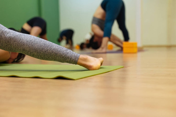 Bir kadının ayaklarının diğer insanlarla yoga yapmasının ayrıntıları. Yoga - Fotoğraf, Görsel