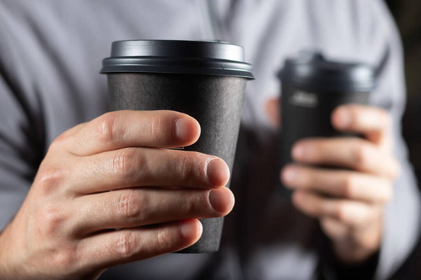 Imagen recortada del hombre sosteniendo dos tazas de café para llevar
, - Foto, Imagen