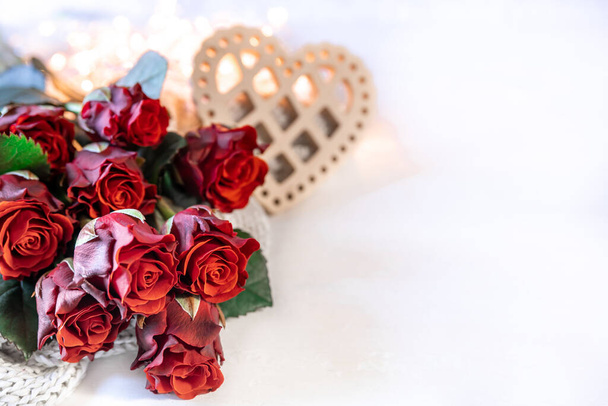 Festive background for Valentines Day with a bouquet of red roses and wooden hart, copy space. - Photo, Image