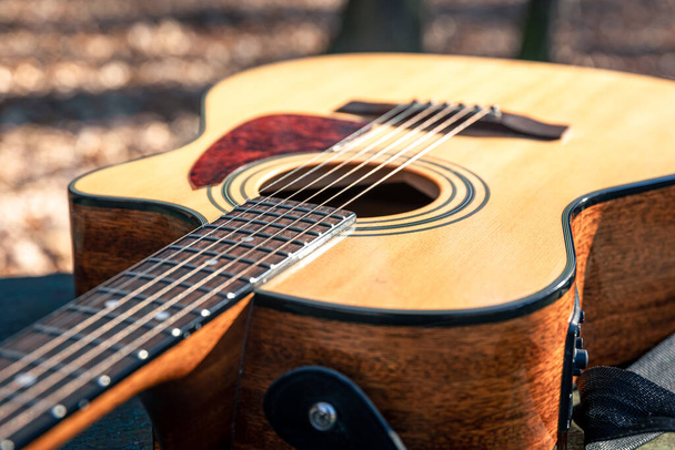 Close-up, klassieke houten akoestische gitaar, zachte focus bij daglicht. - Foto, afbeelding
