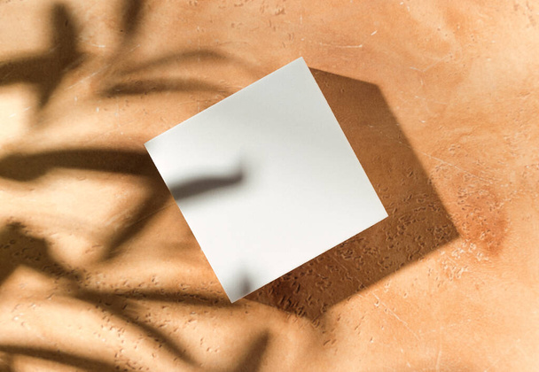 Empty white square mockup podium for product presentation on a sandy textured background with hard light and shadows. Trendy design flat lay with copy space. Top view. - Foto, imagen