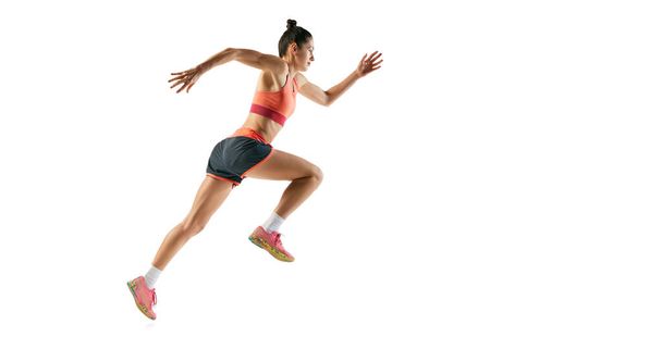 Hareket halindeki bir sporcu. Spor üniformalı sporcu bir kızın profil görüntüsü beyaz arka planda izole edilmiş bir eğitim. Dinamik hareketler, koşu tekniği. İlan için alanı kopyala - Fotoğraf, Görsel