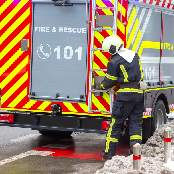 пожежник працює на своїй пожежній машині. служба пожежної безпеки
 - Фото, зображення