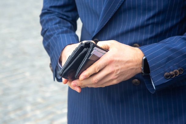 businessman in a suit opens his business leather wallet close up - Foto, imagen