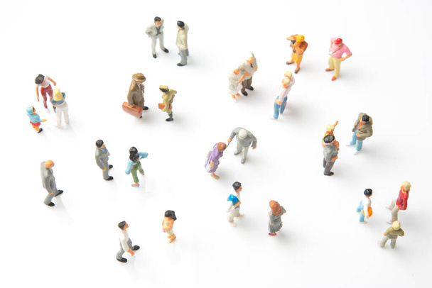 Miniaturmenschen. Auf weißem Hintergrund stehen verschiedene Menschen. Kommunikation der Gesellschaft verschiedener Generationen - Foto, Bild