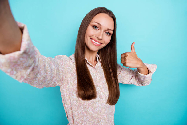 Photo of funky millennial woman do selfie show thumb up wear pink shirt isolatedon blue color background. - Foto, Bild