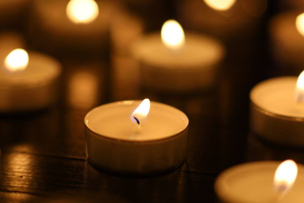 Many small candles on a black background. Bight Lights of candles - Photo, Image