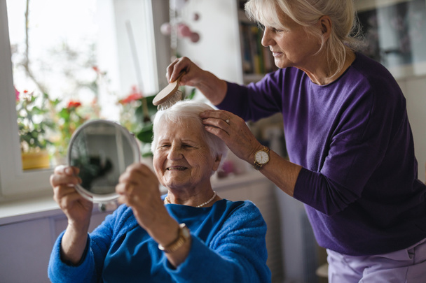 Жінка розчісує волосся літньої матері
  - Фото, зображення