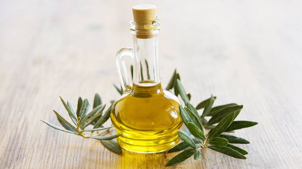 Olivenöl und Olivenbeeren auf dem Holztisch  - Foto, Bild