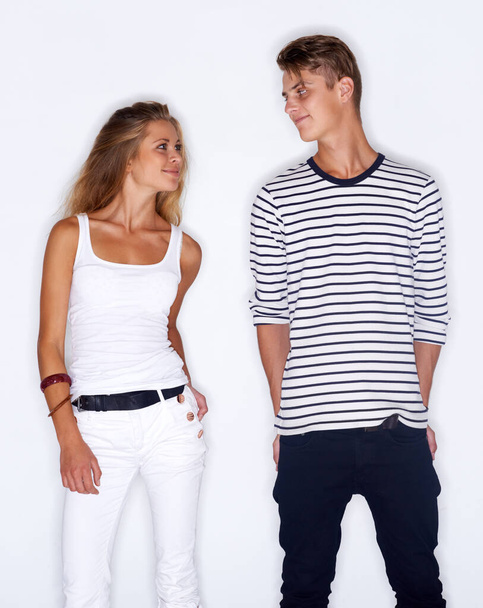 Fashion fever. Young trendy couple standing together on white background - Zdjęcie, obraz