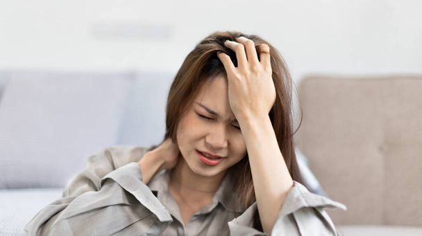 Stressed woman holding her temples with severe problems in her life, Family problems, Pressure from work, Poor financial, Despair in life, discouraged and deeply saddened, Panic attacks. - Photo, Image