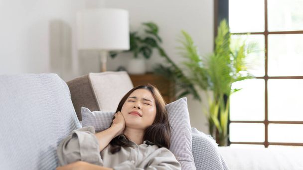 Woman lying chills with high fever on sofa, Severe illness, Headache, Sore throat, High fever, Not taking care of your physical health and not exercising causes your immune system to be low - Fotoğraf, Görsel