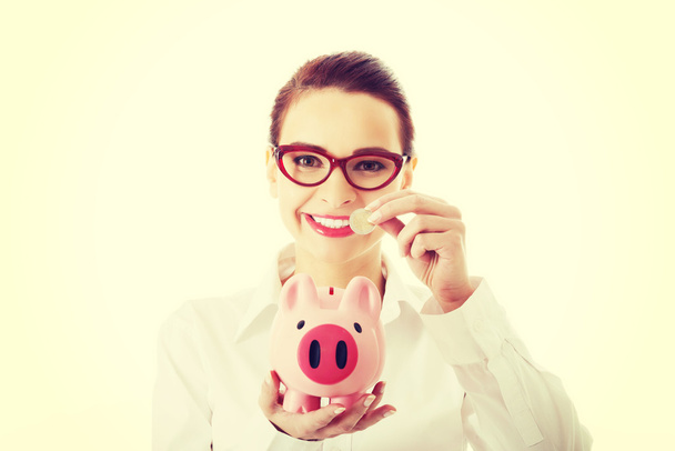 Business woman with coin and piggy- bank. - Fotó, kép