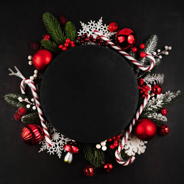 黒の背景には、テキスト、モミの枝、明るい新年の装飾や赤と白の色のボールを書くための場所。クリスマスの背景. - 写真・画像