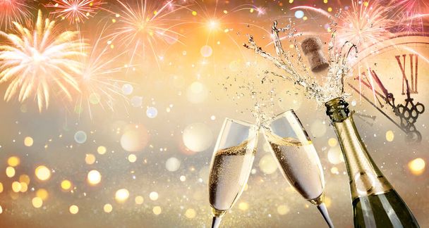  Toast du Nouvel An avec Champagne et feux d'artifice - Fête de célébration avec horloge visage avec des lumières abstraites déconcentrées - Photo, image