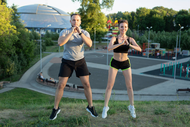 Young couple trains outdoors in a Park in the summer at sunset - Foto, imagen