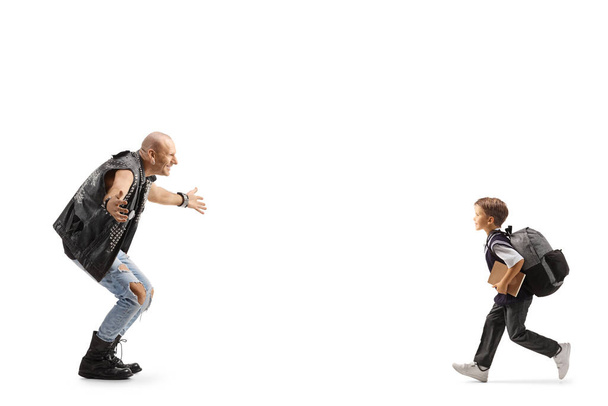 Full length profile shot of a schoolboy running to hug a rock music star isolated on white backgroun - Fotografie, Obrázek