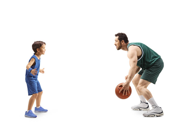 Full length profile shot of an adult playing basketball with a little boy isolated on white background - Foto, imagen