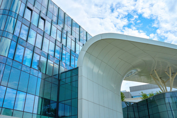 Geometrik şekilli modern şehir mimarisi. Mavi gökyüzüne karşı fütürist bina cephesi. - Fotoğraf, Görsel