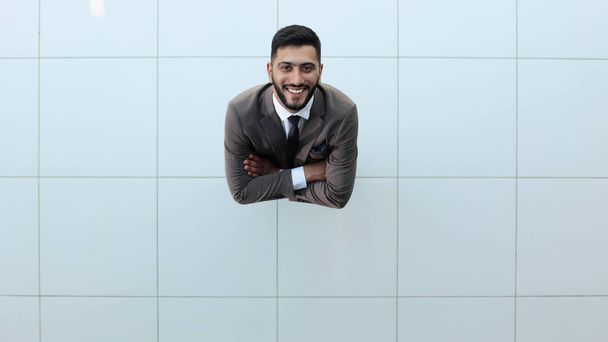 Handsome smiling business man in a suit standing with his arms crossed. View from above - Foto, imagen