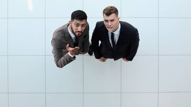Portrait de deux hommes d'affaires concentrés partenaires vêtus de costume formel marche et avoir une conversation pendant la réunion de travail - Photo, image