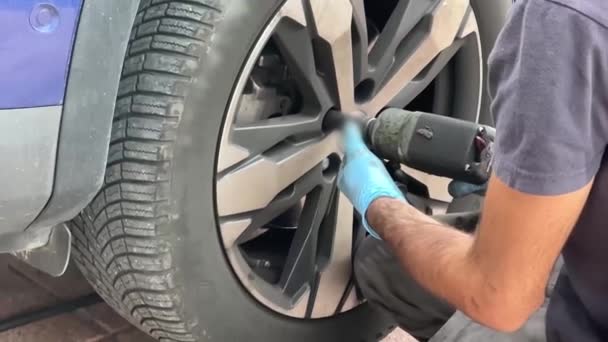 Rivenditore di pneumatici cambia un pneumatico auto. - Filmati, video