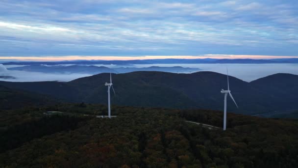 Ветряные турбины в горах во время восхода солнца и густой утренний туман в долине. Ветряная электростанция. - Кадры, видео