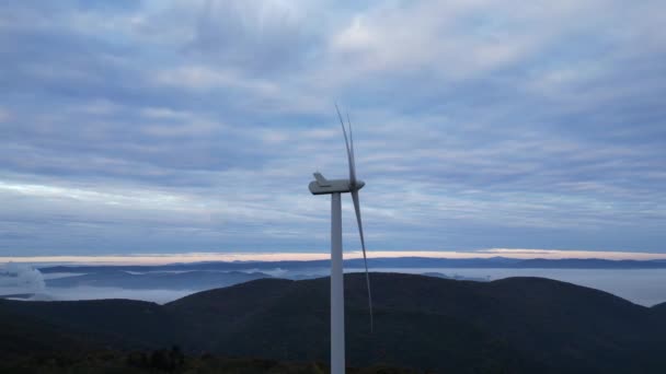 Вітрові турбіни в горах під час сходу сонця і густий ранковий туман в долині. Вітроенергетика виробляє зелену енергію
. - Кадри, відео