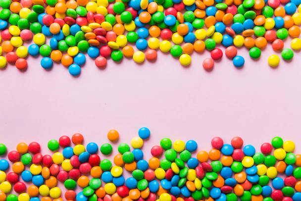 Mixed collection of colorful candy, on colored background. Flat lay, top view. frame of colorful chocolate coated candy. - Photo, Image